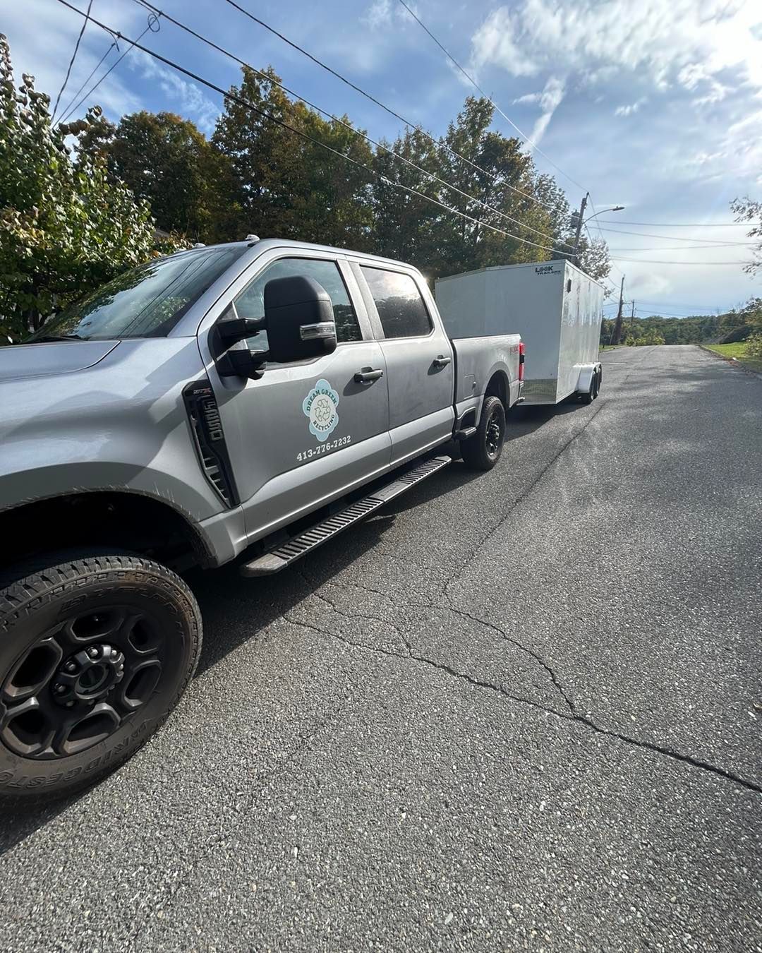 A truck is towing a trailer down a road.