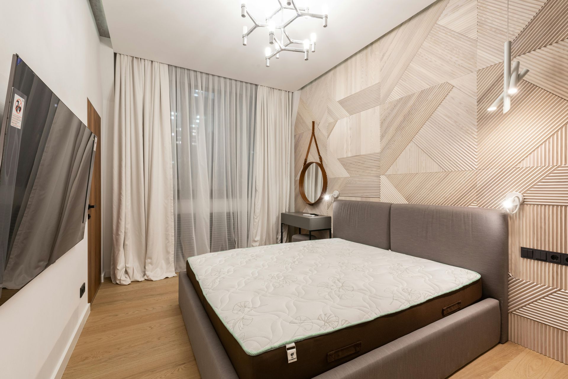 A bedroom with a large bed and a mirror on the wall.