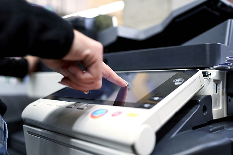 Una persona sta premendo un pulsante su una stampante.