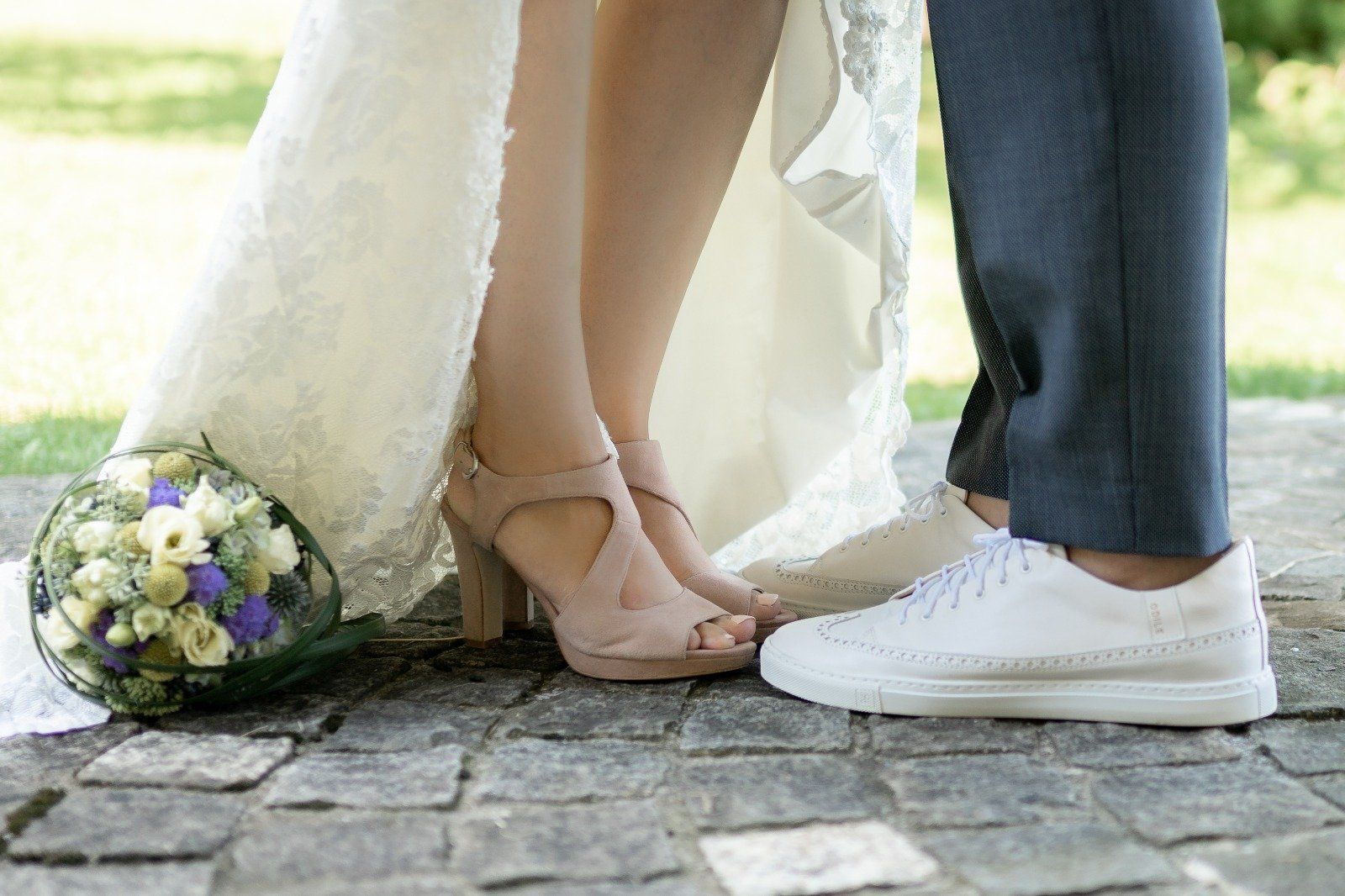 Bräute mit weißem lila Strauß auf dem Boden