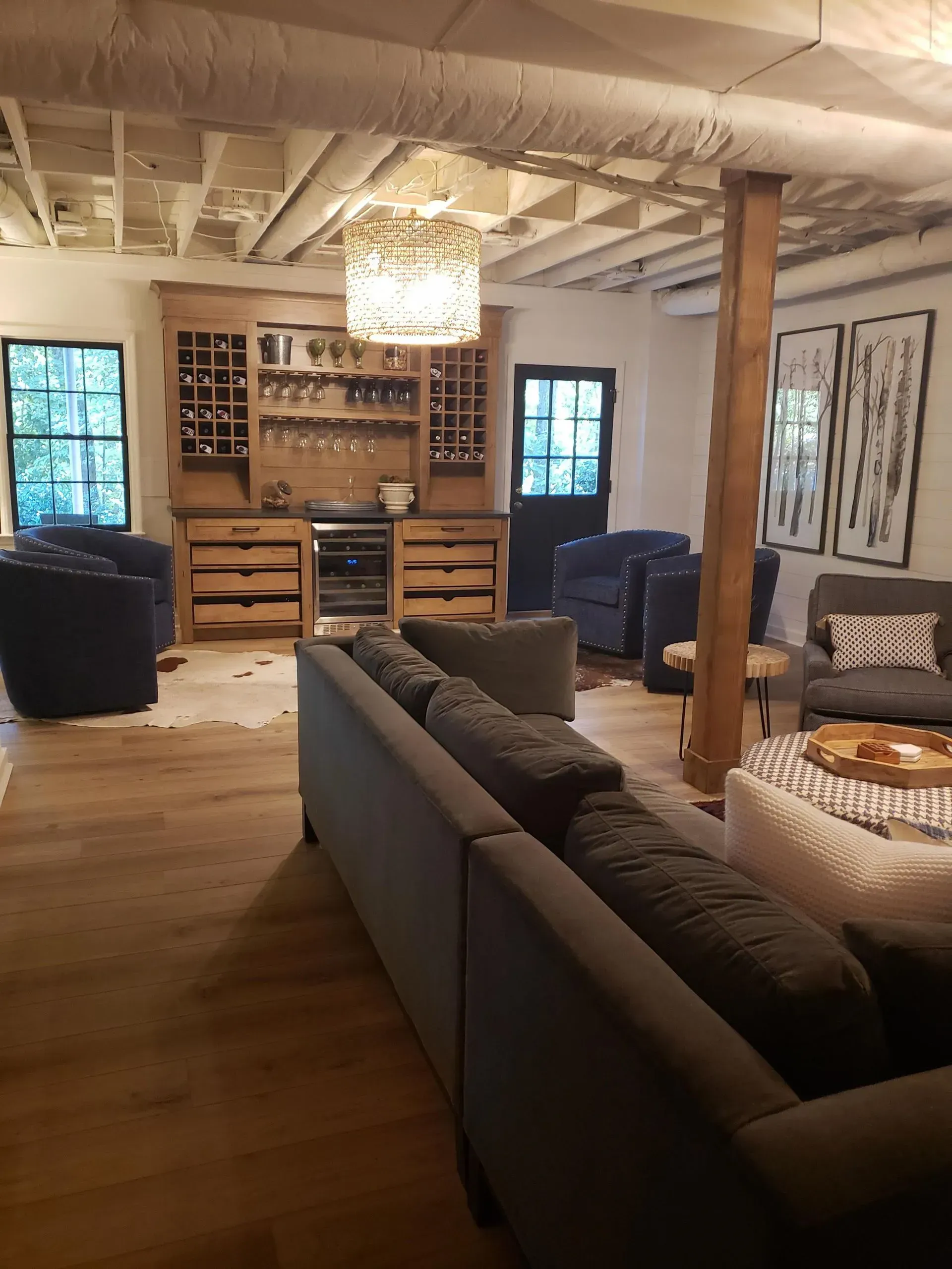 Living room with a wooden bar, seating area, and exposed ceiling beams.