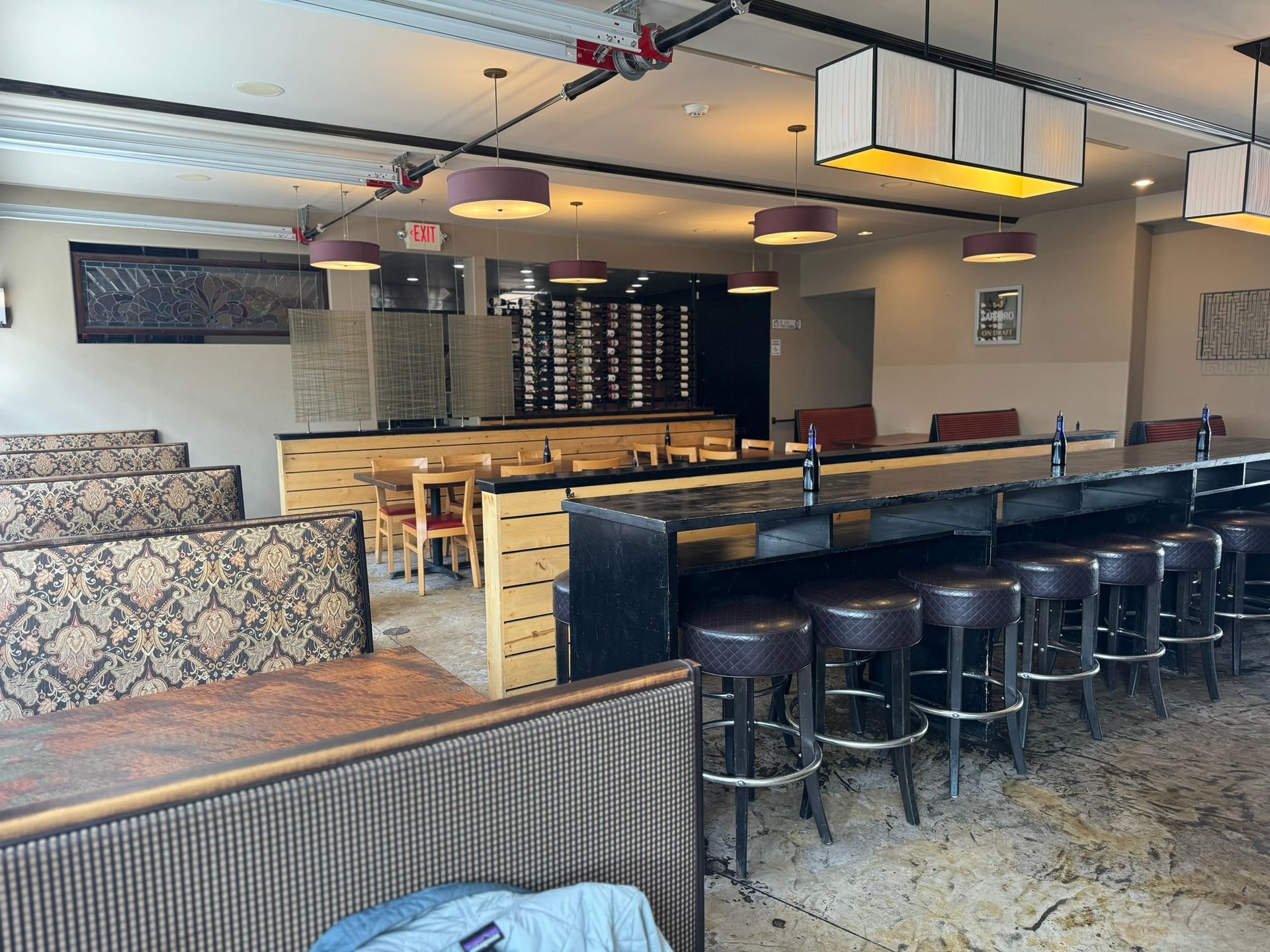 The inside of a restaurant with tables and stools