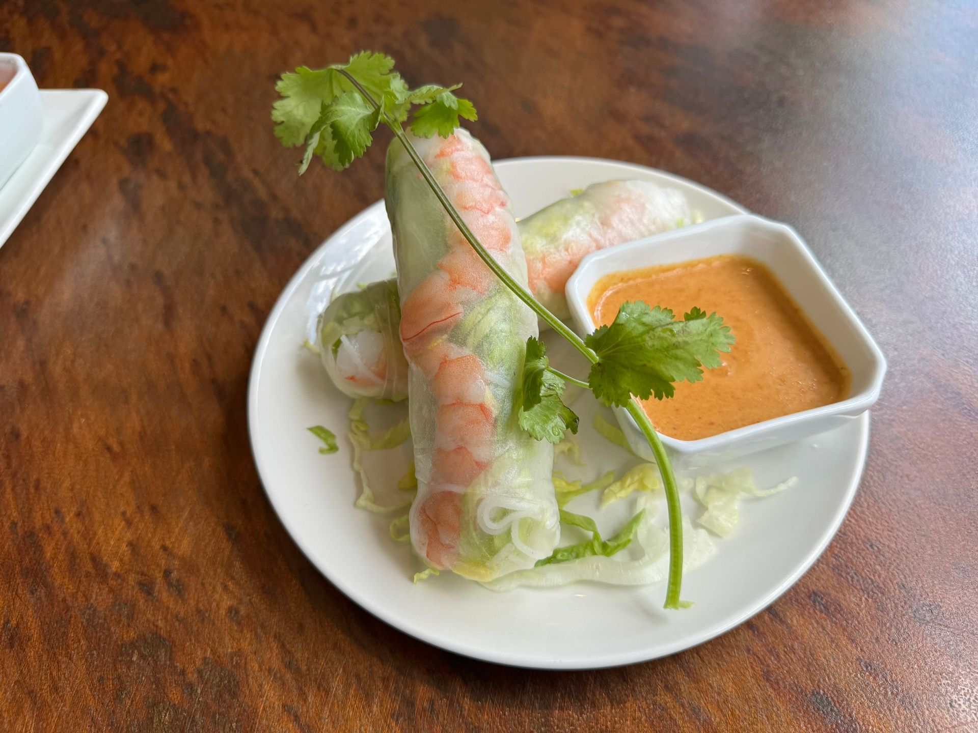 A plate of food with a dipping sauce on a wooden table.