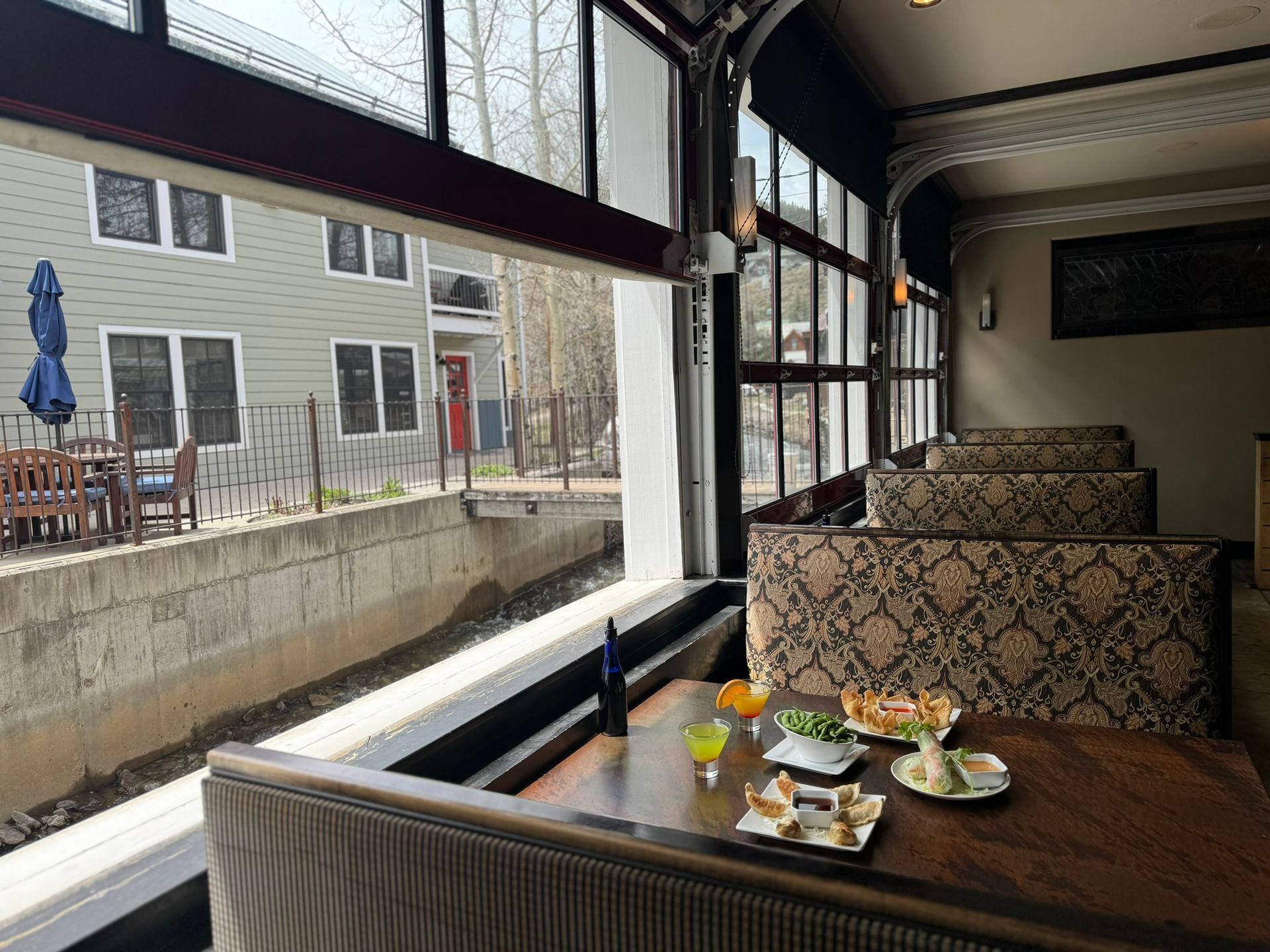 A restaurant with a lot of windows and a table with food on it.