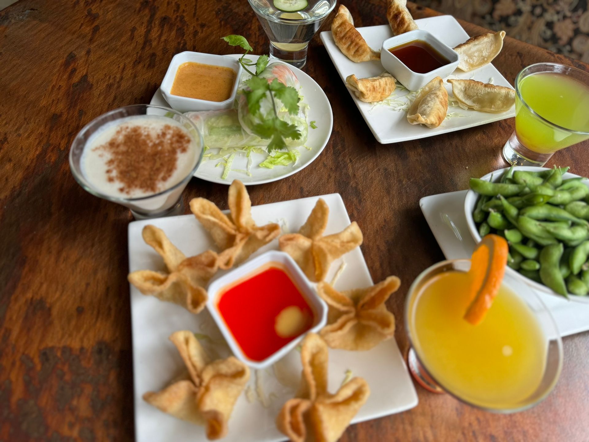 A wooden table topped with plates of food and drinks