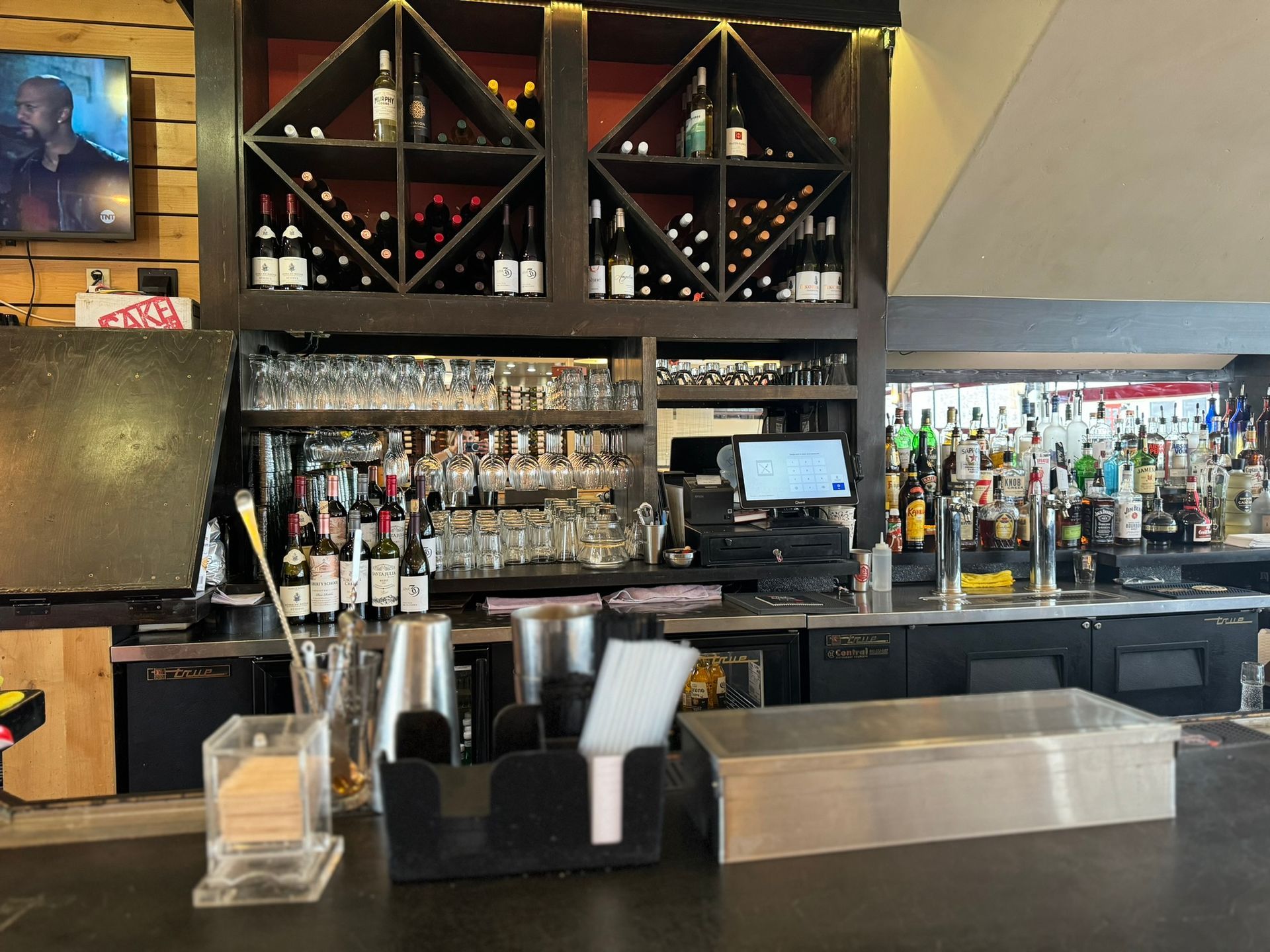 A bar with a lot of bottles and glasses on it