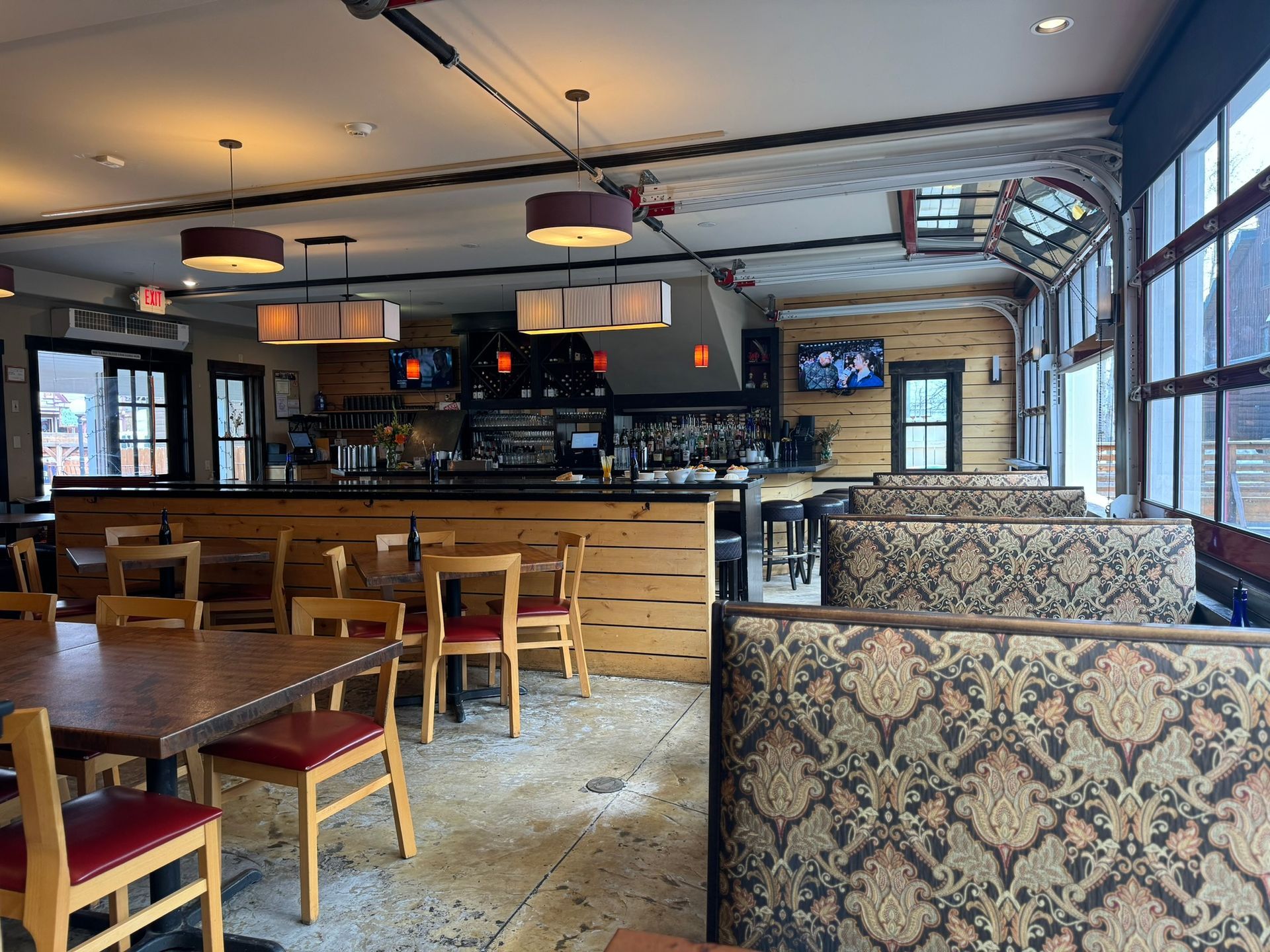 A restaurant with tables and chairs and a bar.