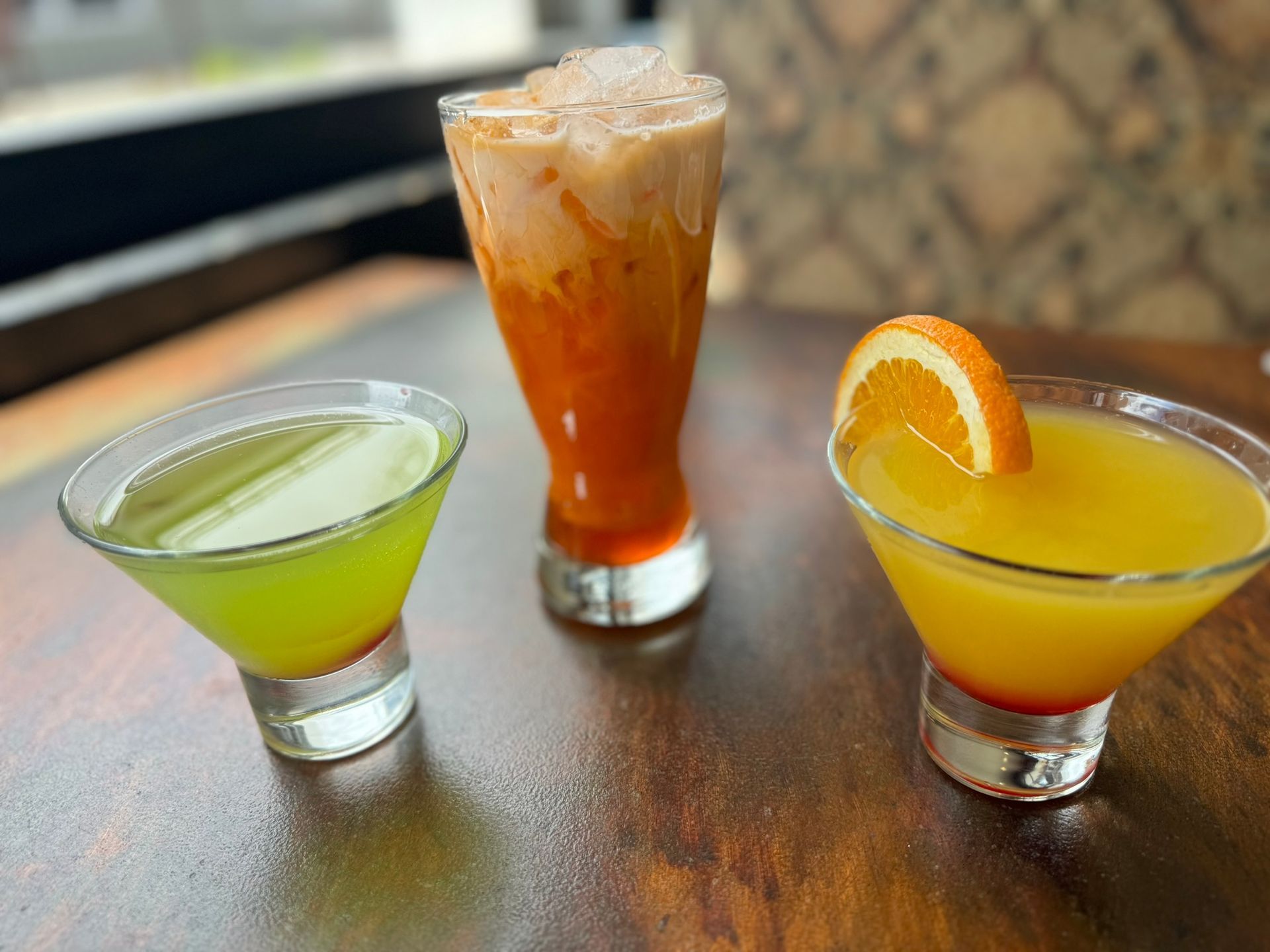 Three different types of drinks are sitting on a wooden table.