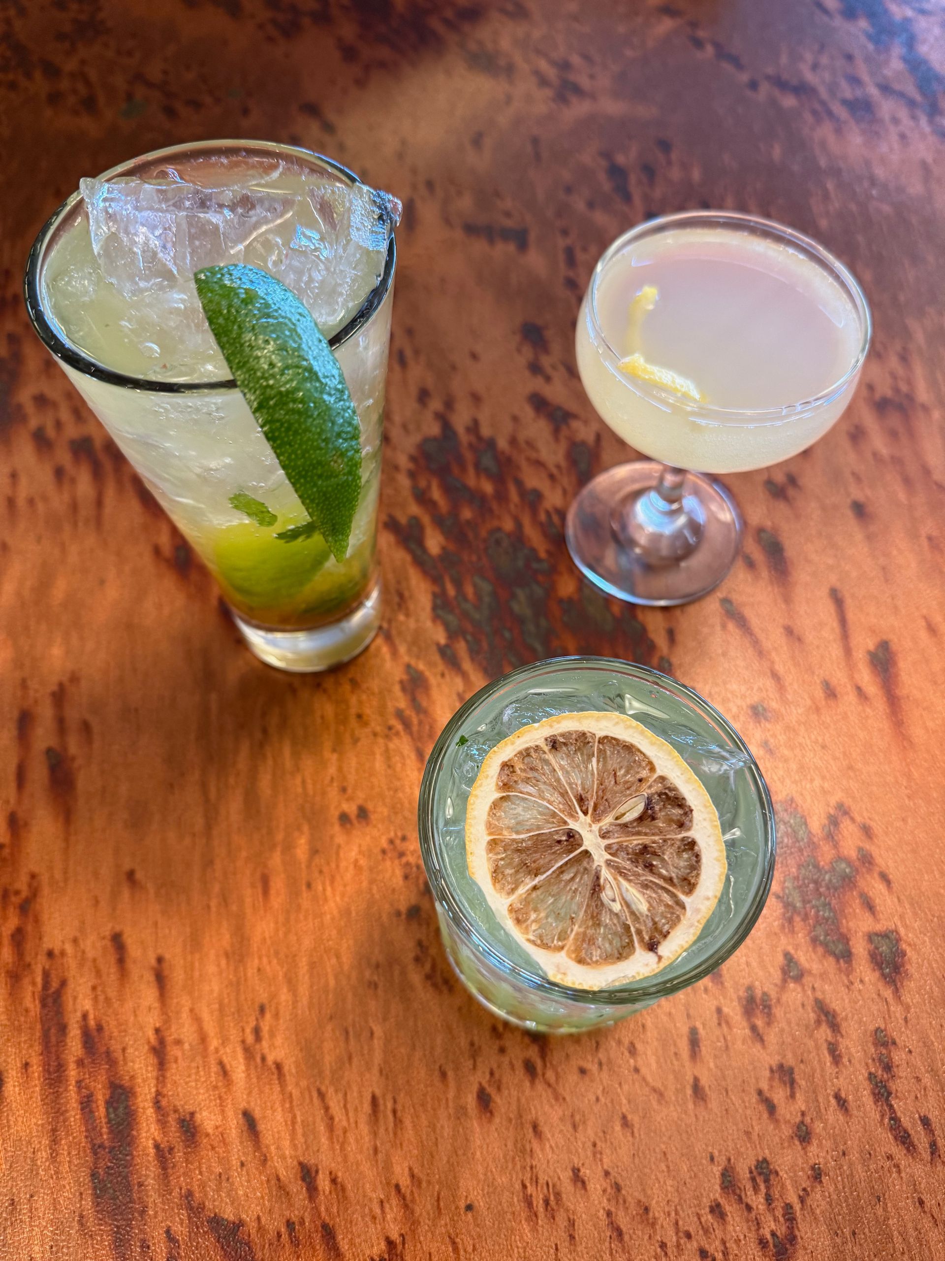 Three different types of drinks are sitting on a wooden table.