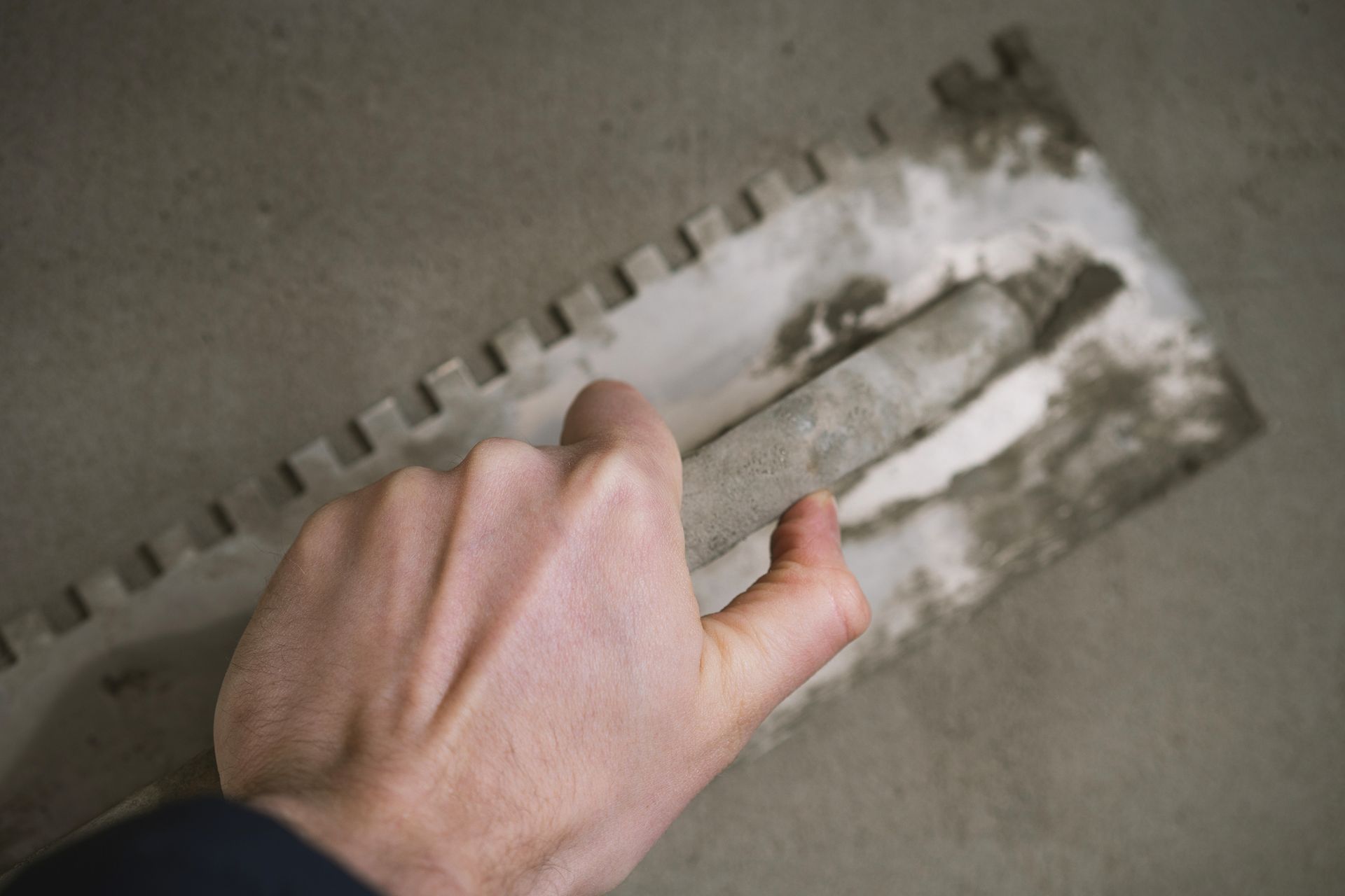 Close-up of a hand applying plaster to a wall