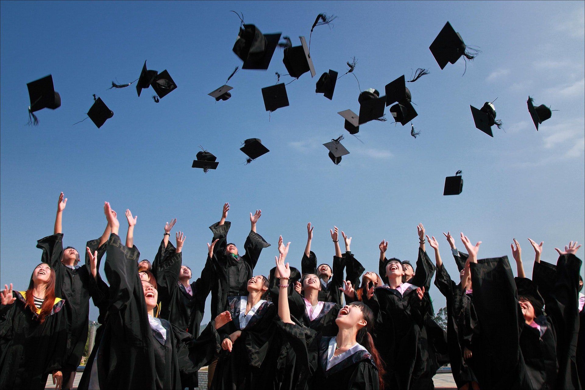 A group of graduates are throwing their caps in the air.