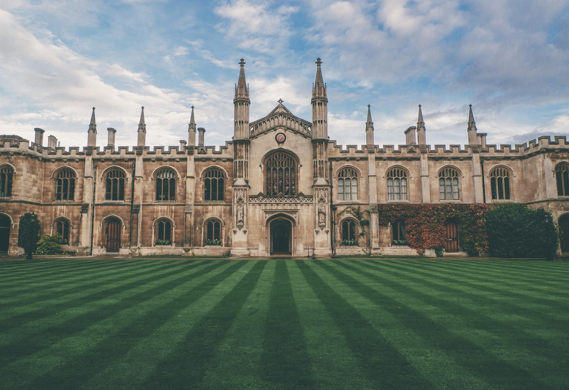 A large building with a lush green lawn in front of it.