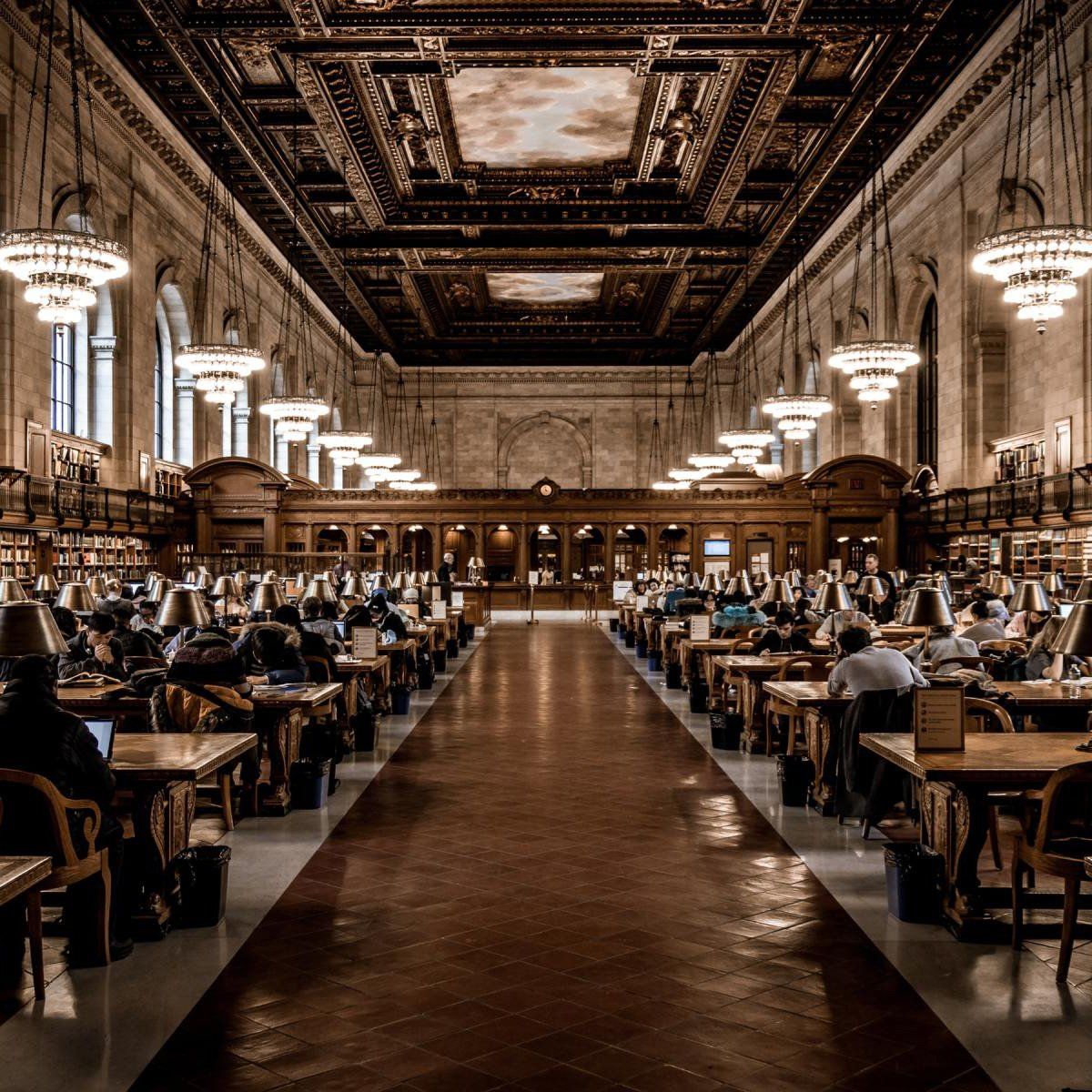 People are sitting at tables in a large library