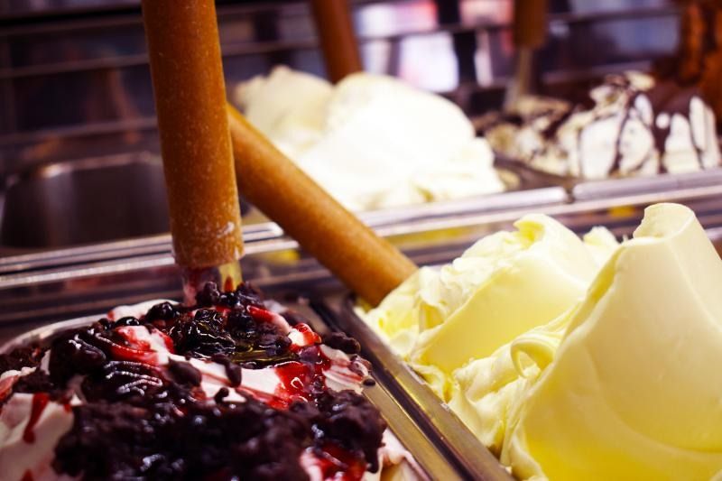 Esposizione di gelato con palline di cioccolato e vaniglia su un vassoio in una gelateria