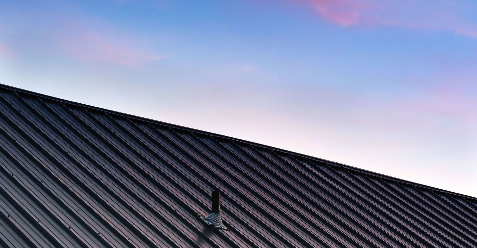 A black roof with a blue sky in the background.