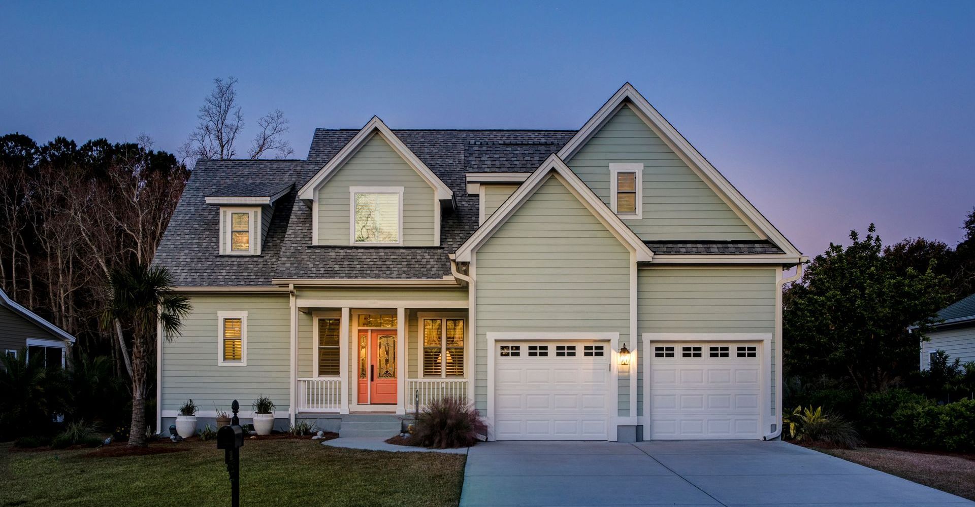 A large house with a white garage door and a red door