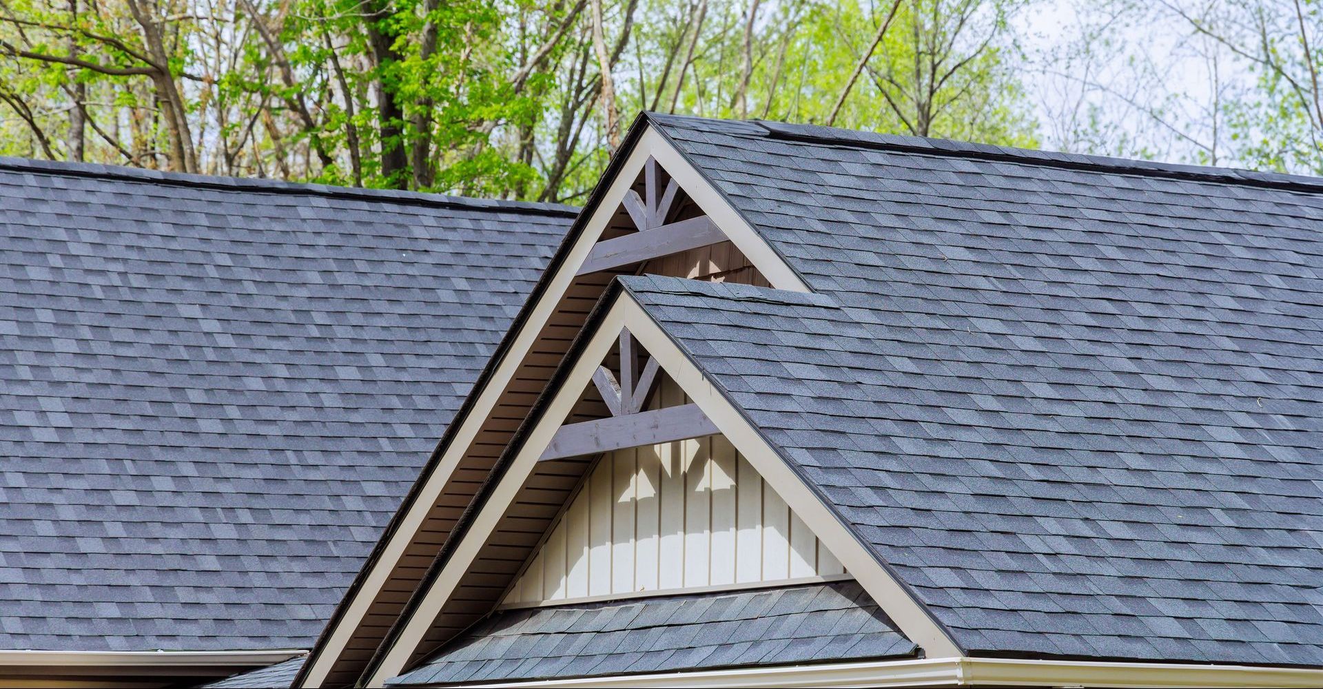 A close up of a roof of a house with trees in the background.