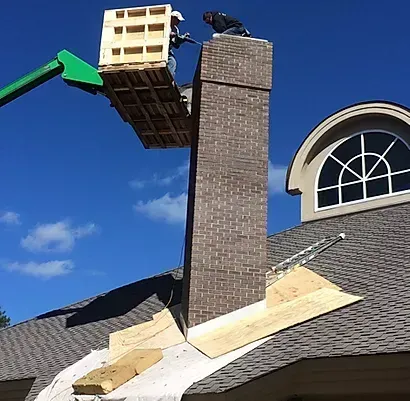 Man On Lift Repairing Chimney - Calabash, NC - Roof Doctor Of The Carolinas Inc.