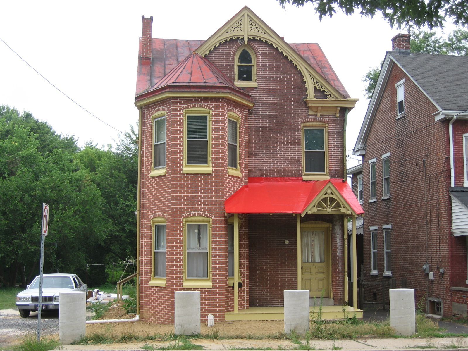 A brick house with a red awning on the front