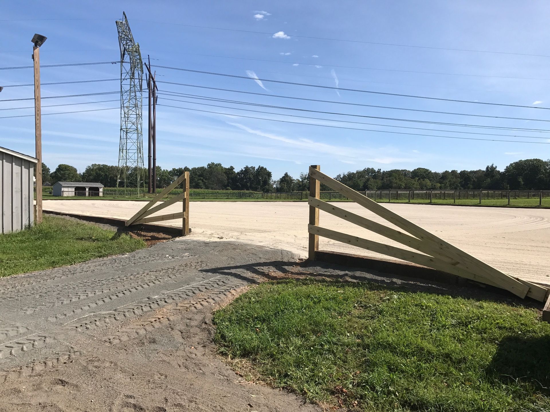 A wooden fence is sitting in the middle of a dirt field.