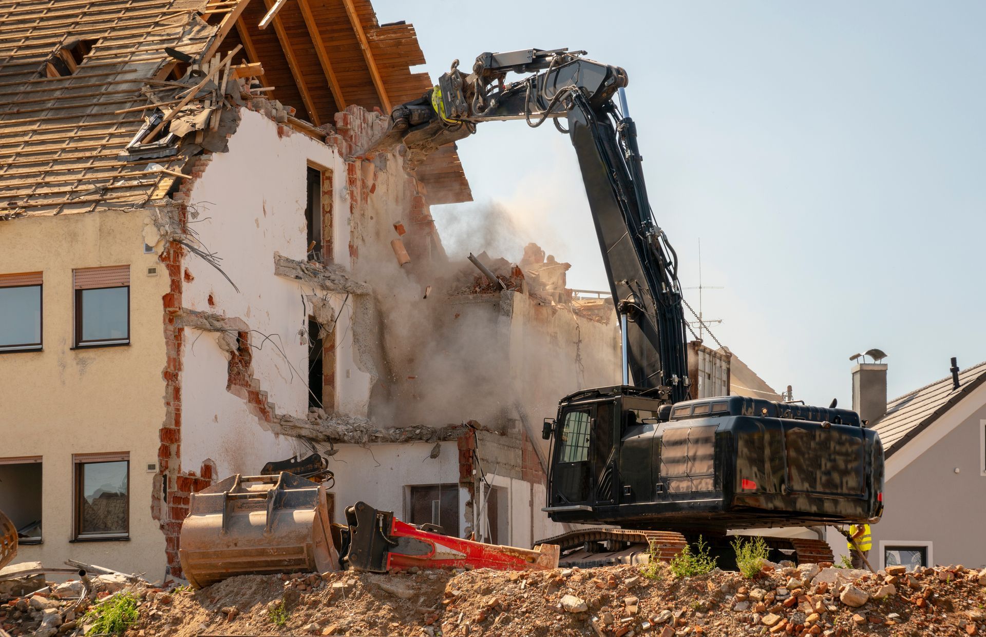 A house is being demolished by a large excavator.