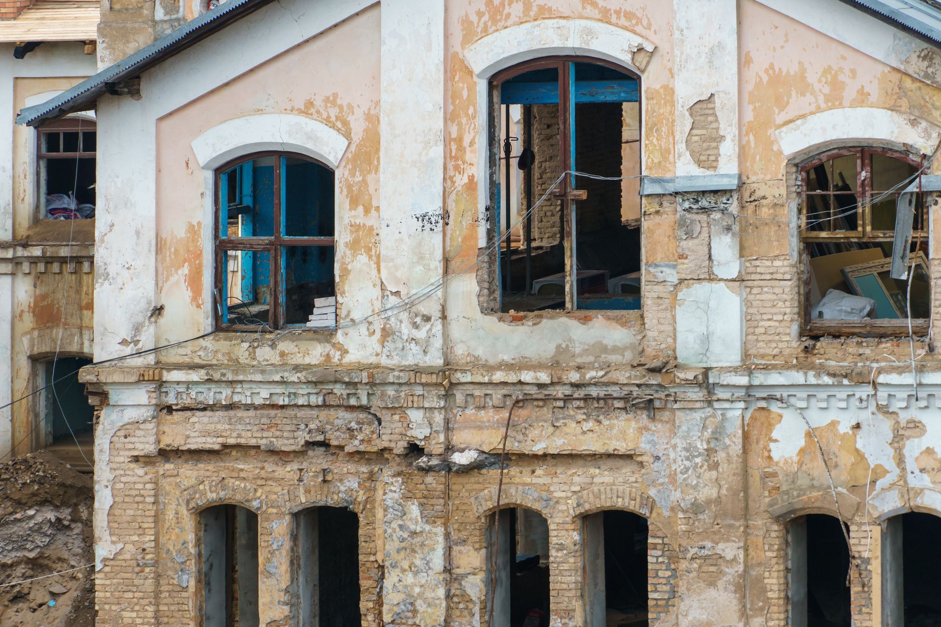 An old brick building with a lot of windows is being demolished.