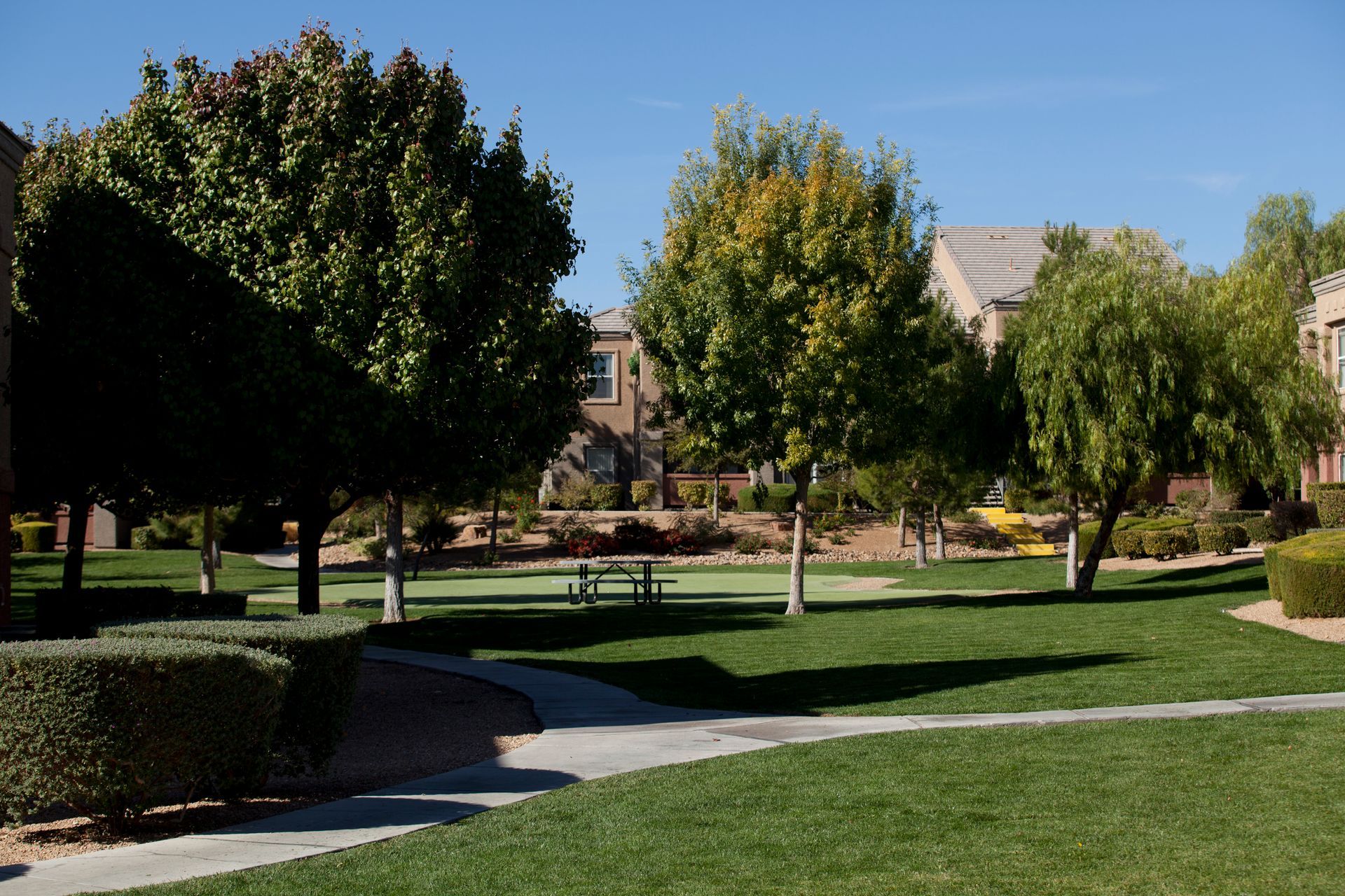 A park with trees and a picnic table in the middle