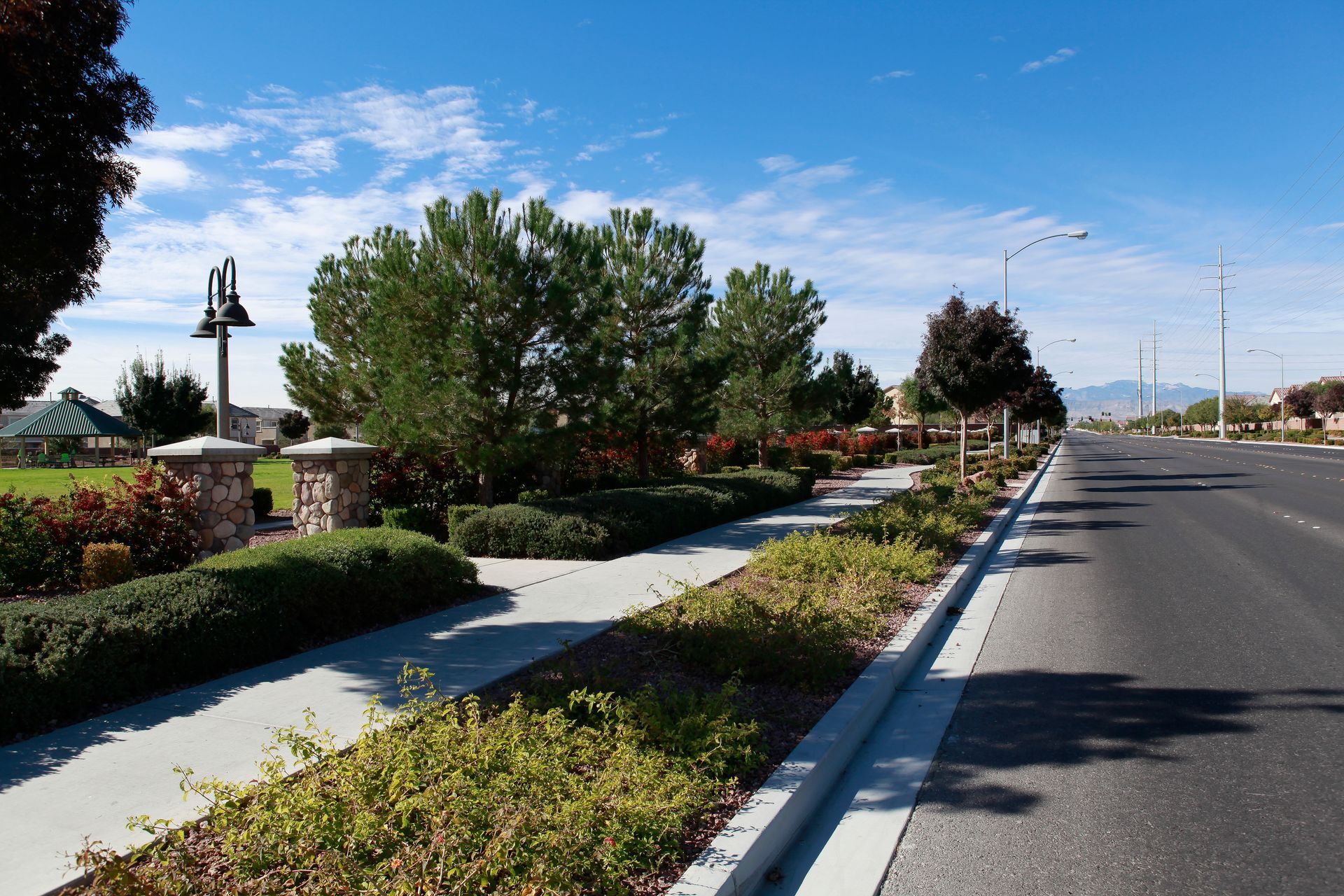 A street with a sidewalk and trees on the side of it
