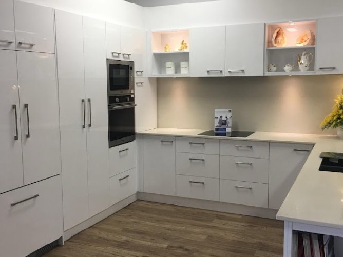 A kitchen with white cabinets and a stove top oven