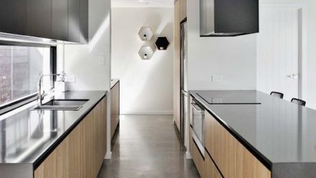 A kitchen with stainless steel appliances and wooden cabinets.