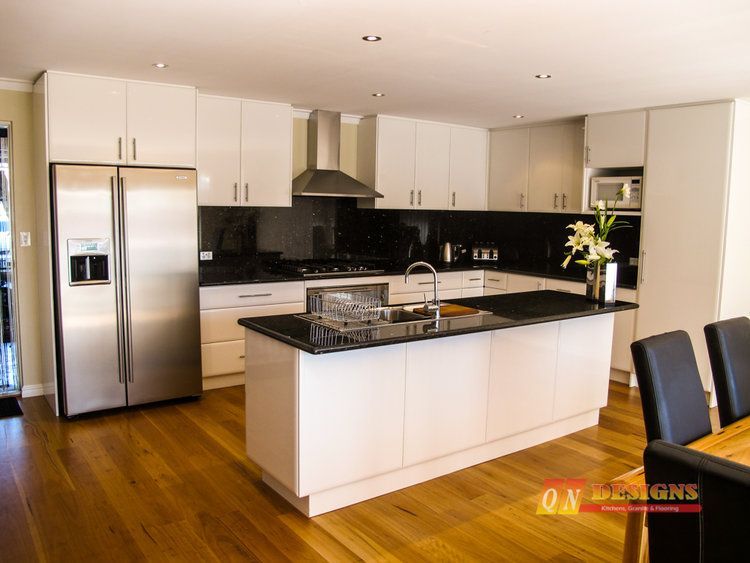 A kitchen with stainless steel appliances and white cabinets