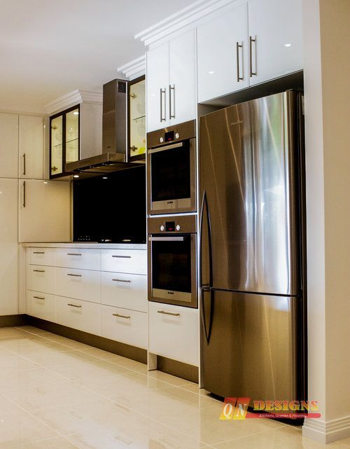 A kitchen with stainless steel appliances and white cabinets
