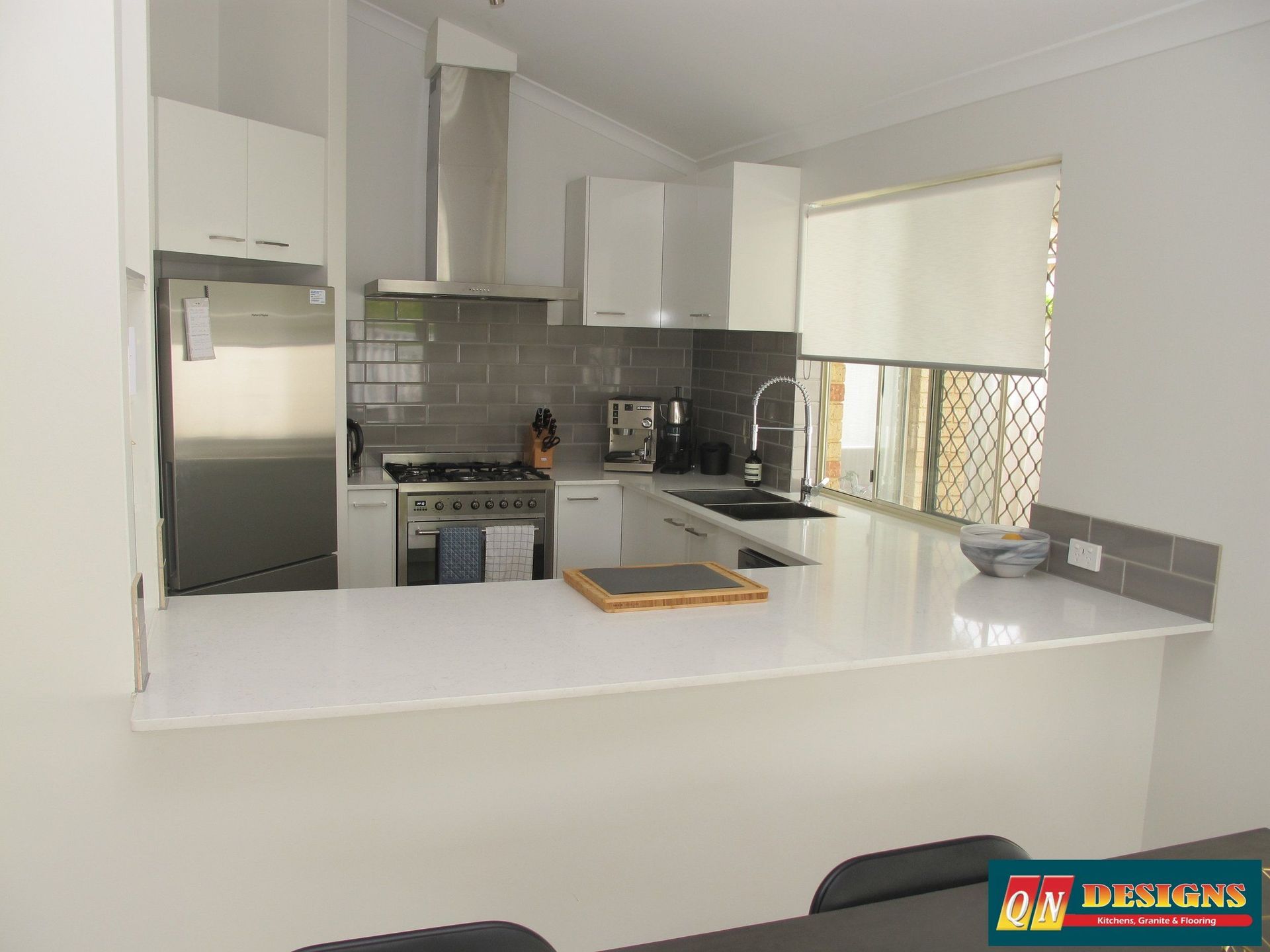 A kitchen with white cabinets and stainless steel appliances