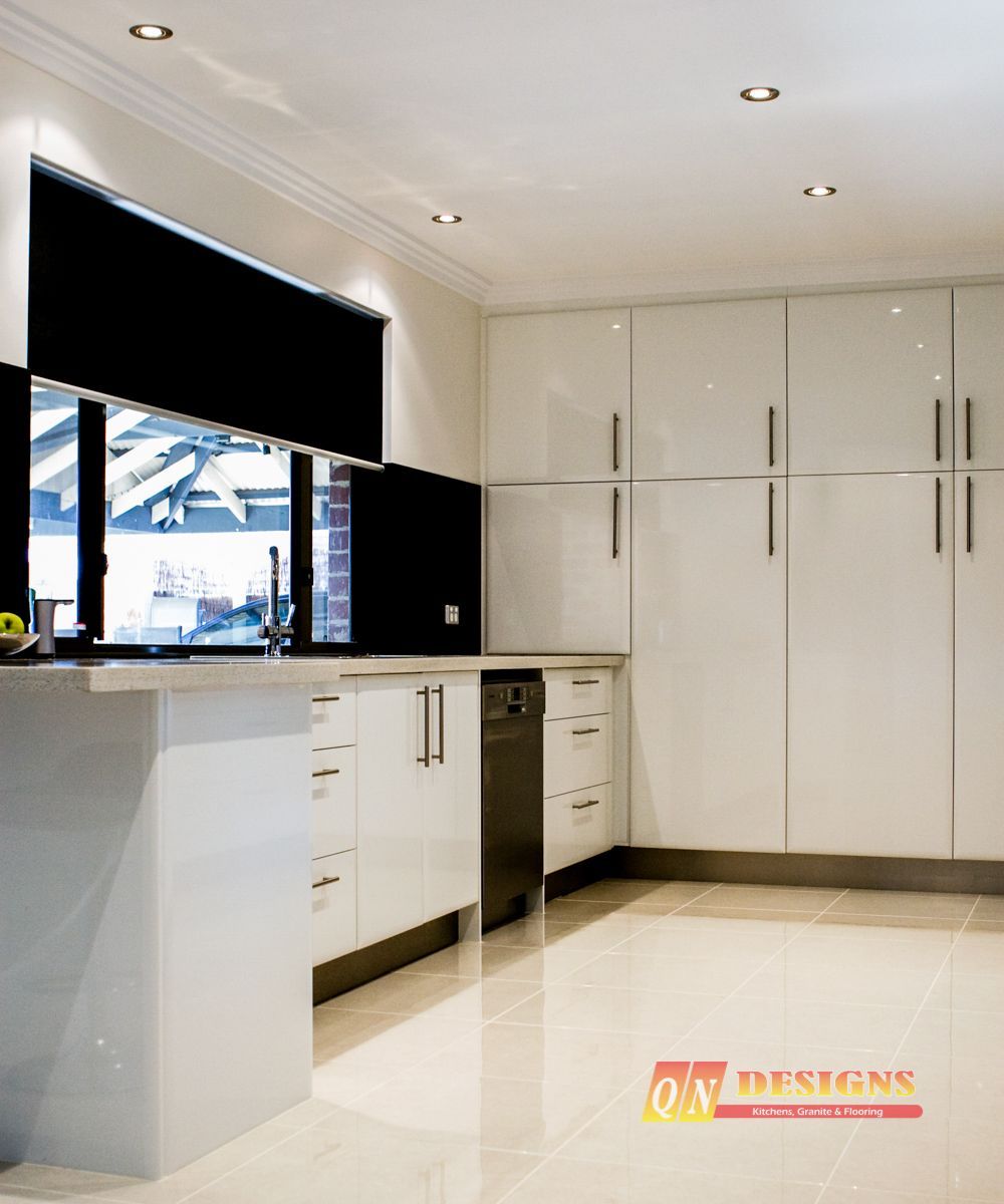 A kitchen with white cabinets and black blinds