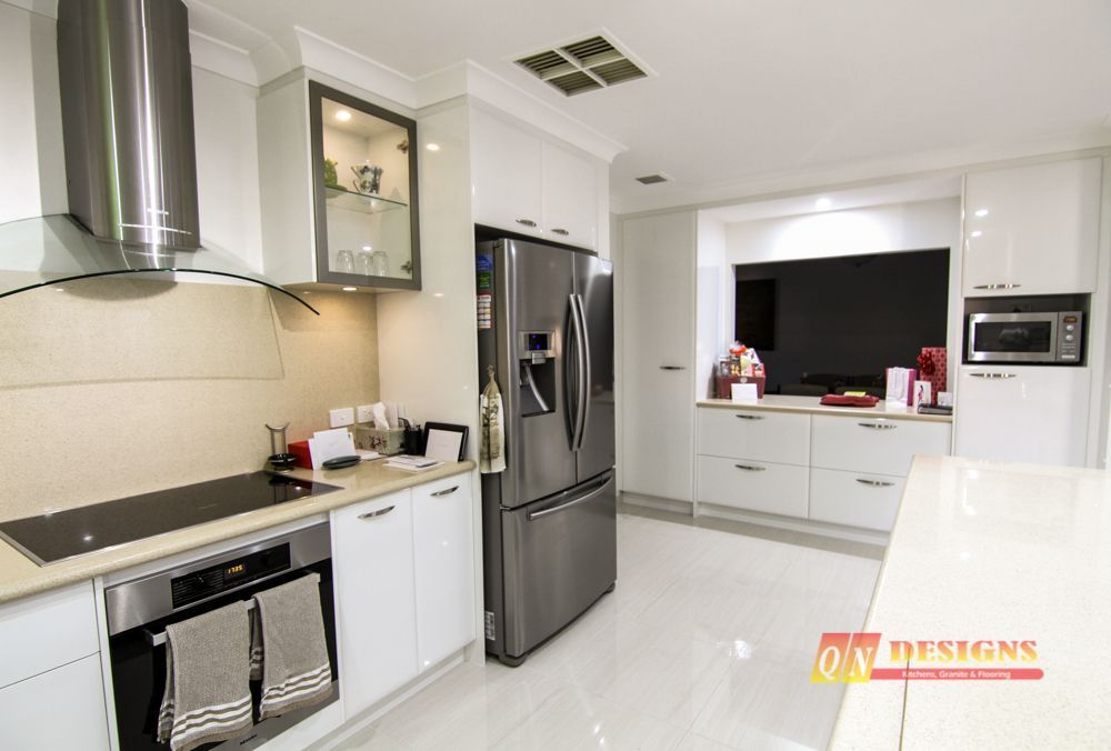 A kitchen with white cabinets and stainless steel appliances