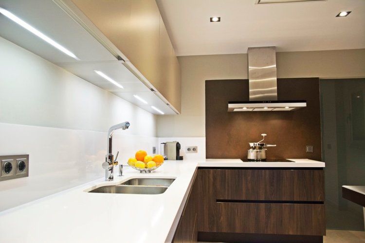 A kitchen with a sink and a stove top oven