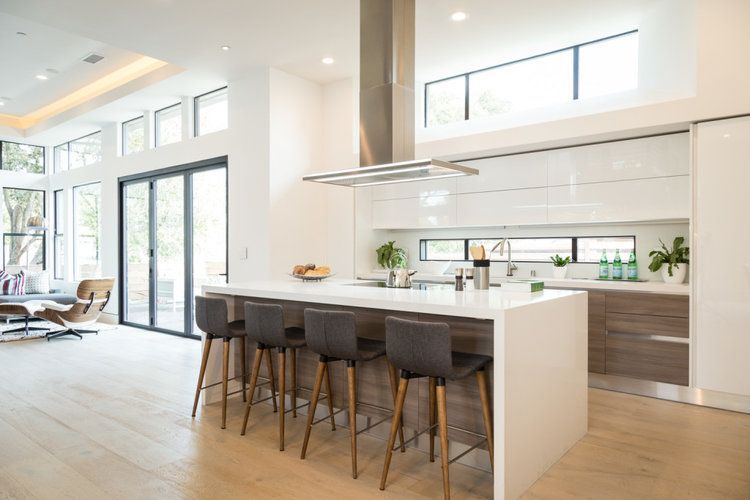 A modern kitchen with a large island and stools.