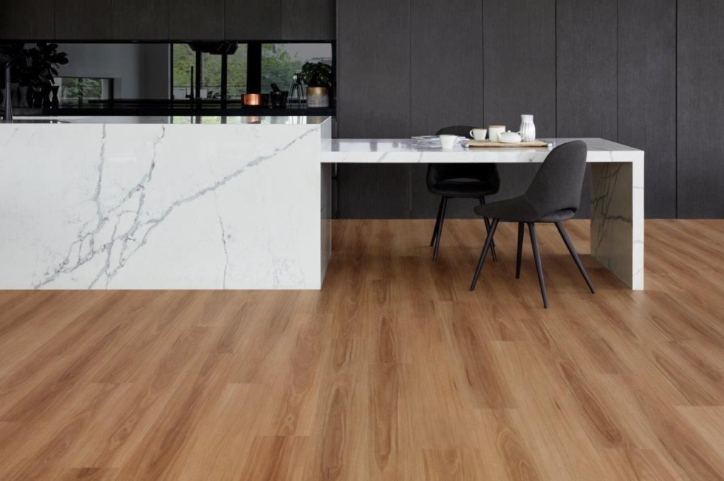 A kitchen with a wooden floor and a marble counter top.