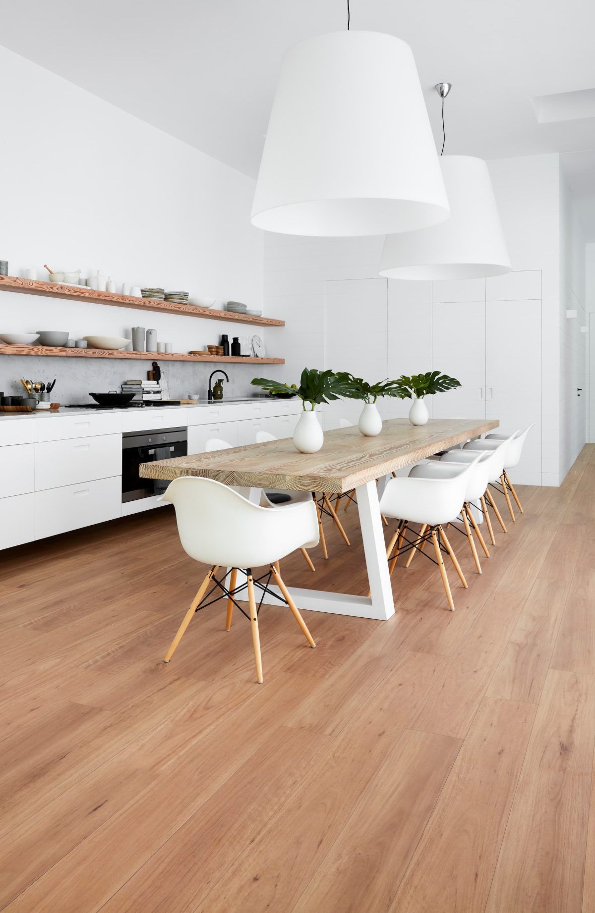 A kitchen with a table and chairs and a wooden floor.