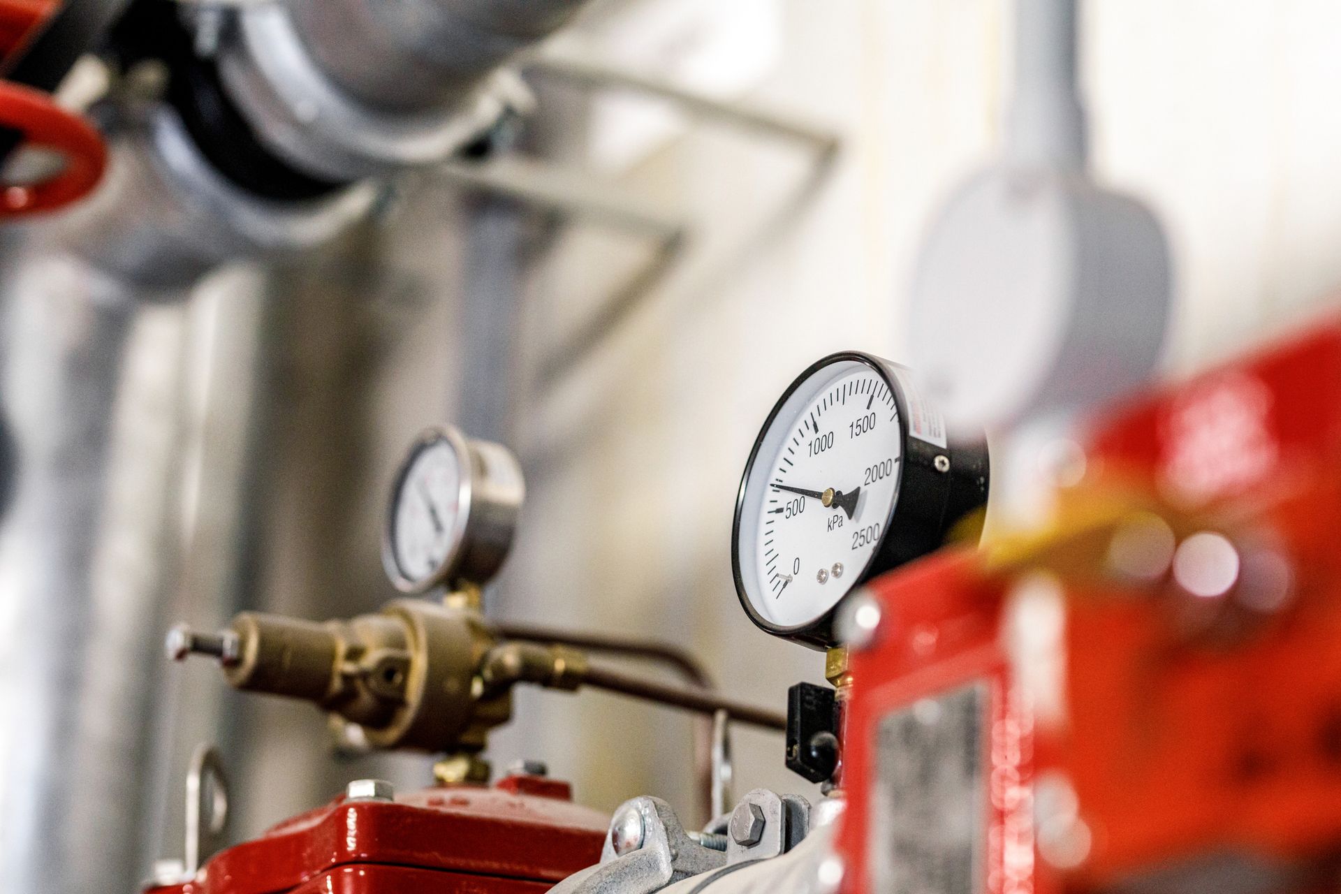 A close up of a pressure gauge on a machine in a factory.
