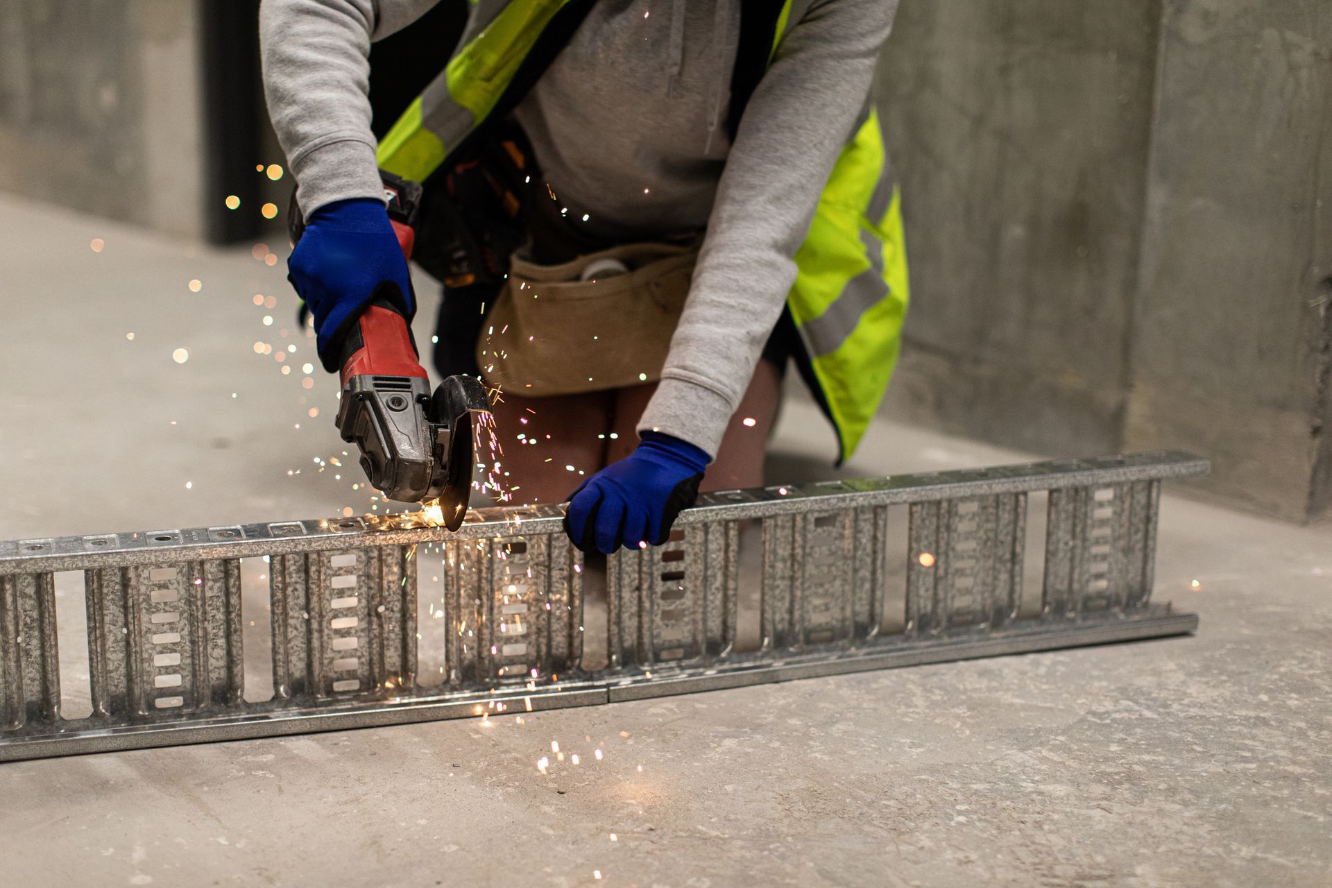 A man is grinding a piece of metal with a grinder.