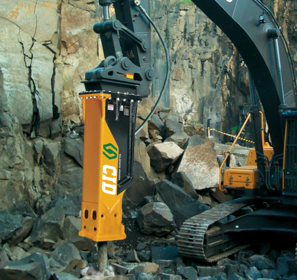 A yellow machine with a rock background