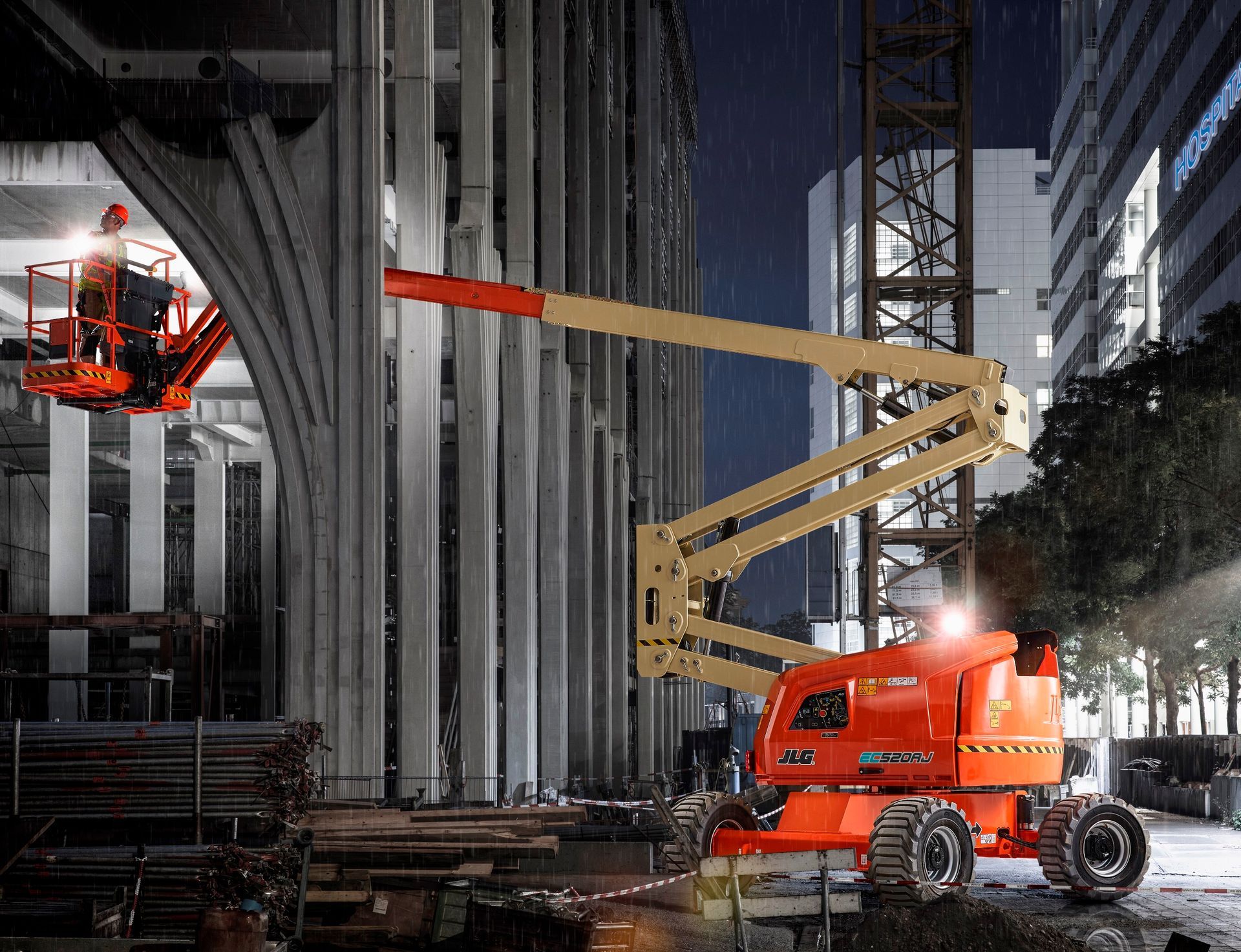 orange machine lifting a man into a building 