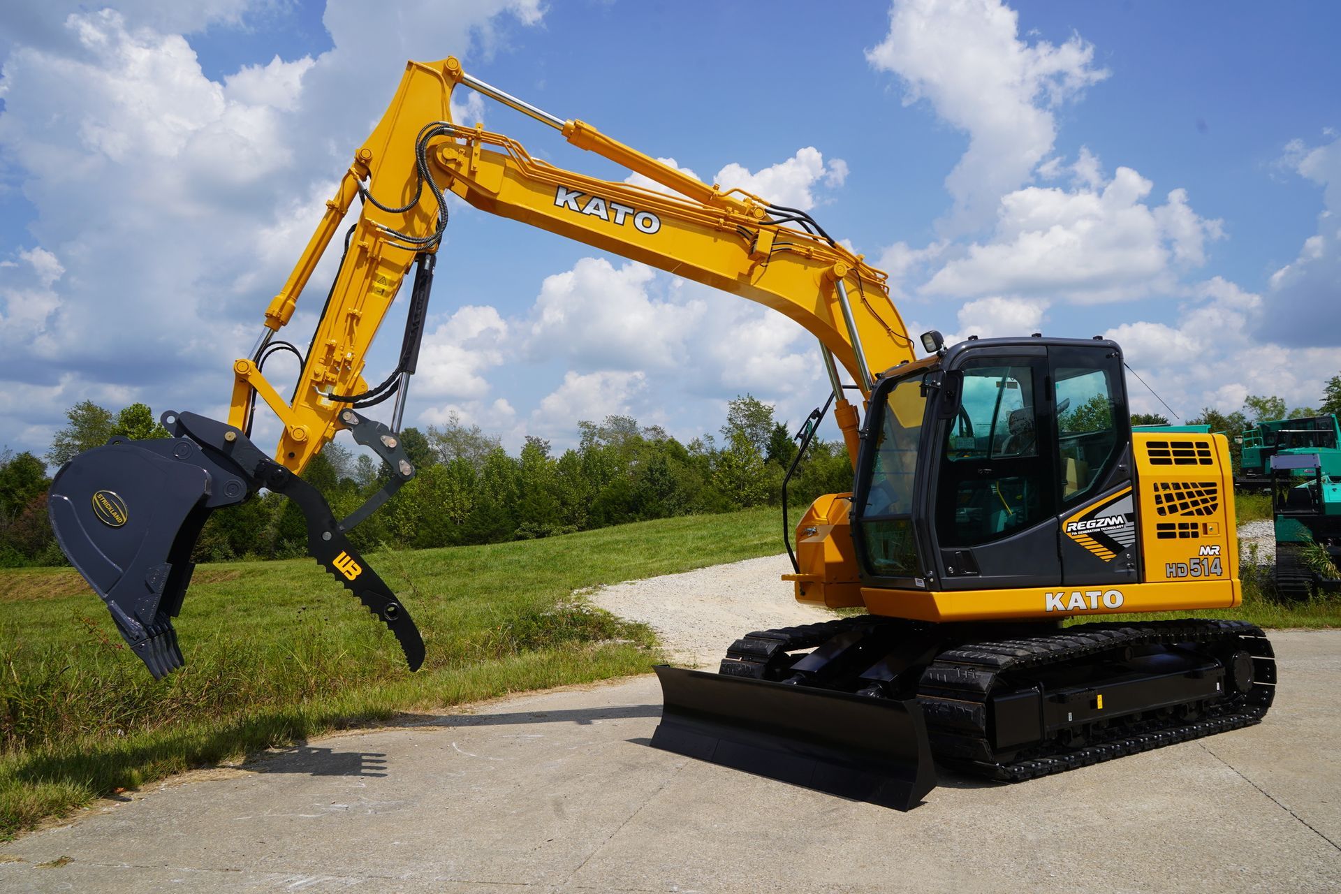 A yellow excavator is on grey pavement