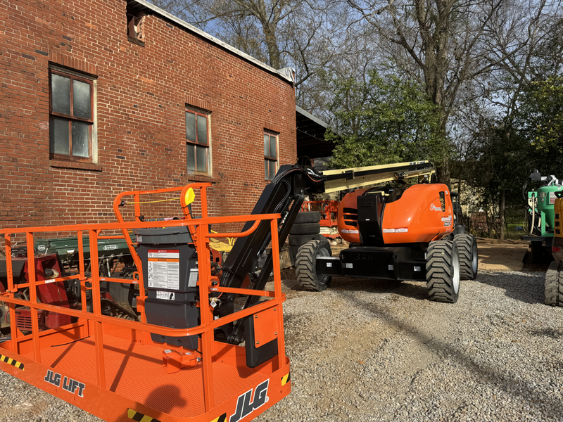 A orange machine in front of a brick building