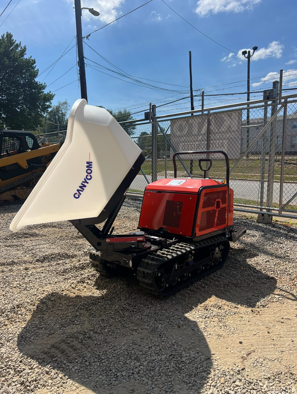 A white dump truck with tracks on gravel