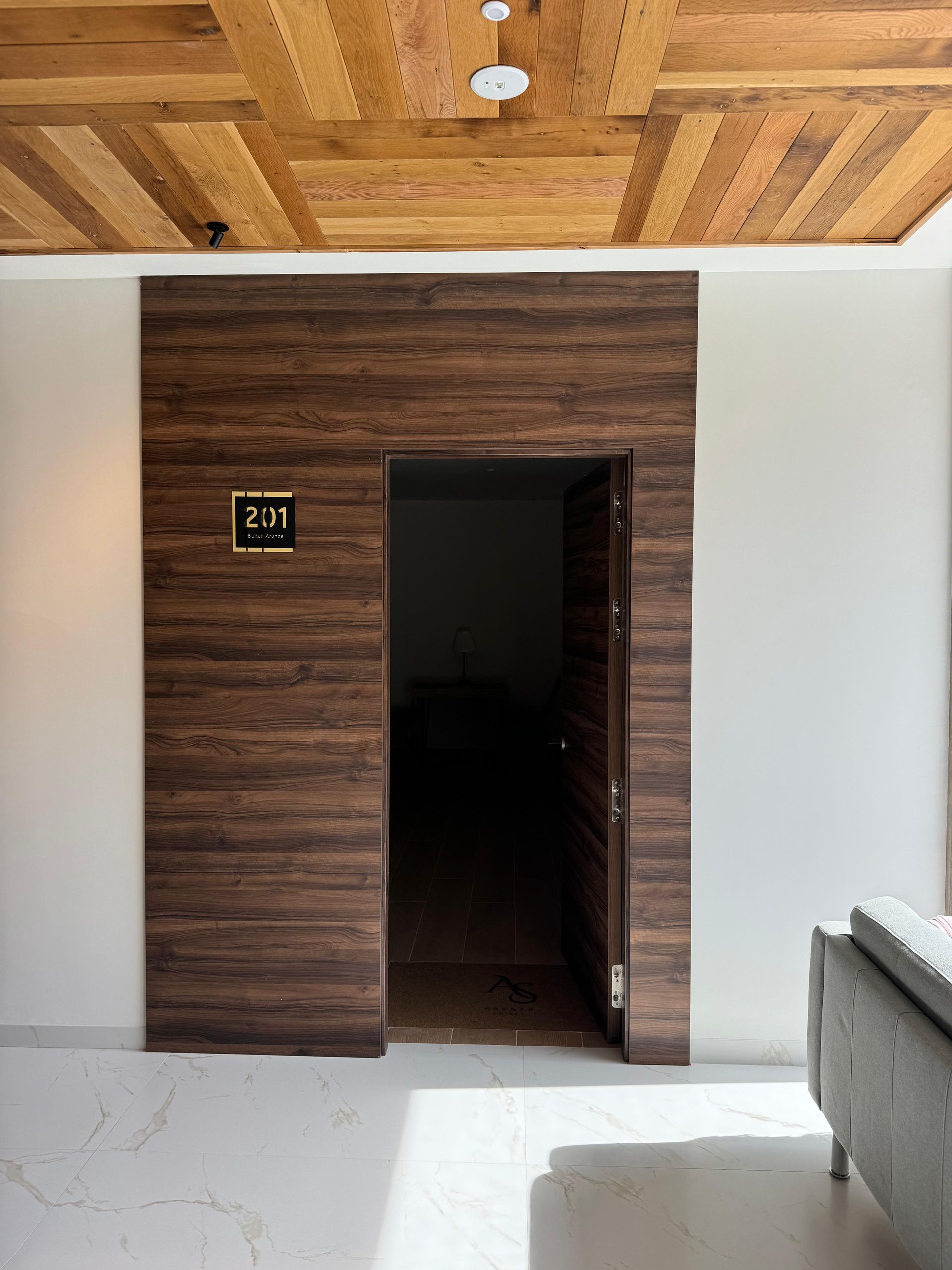 Puerta con paneles de madera y número de habitación 201, 