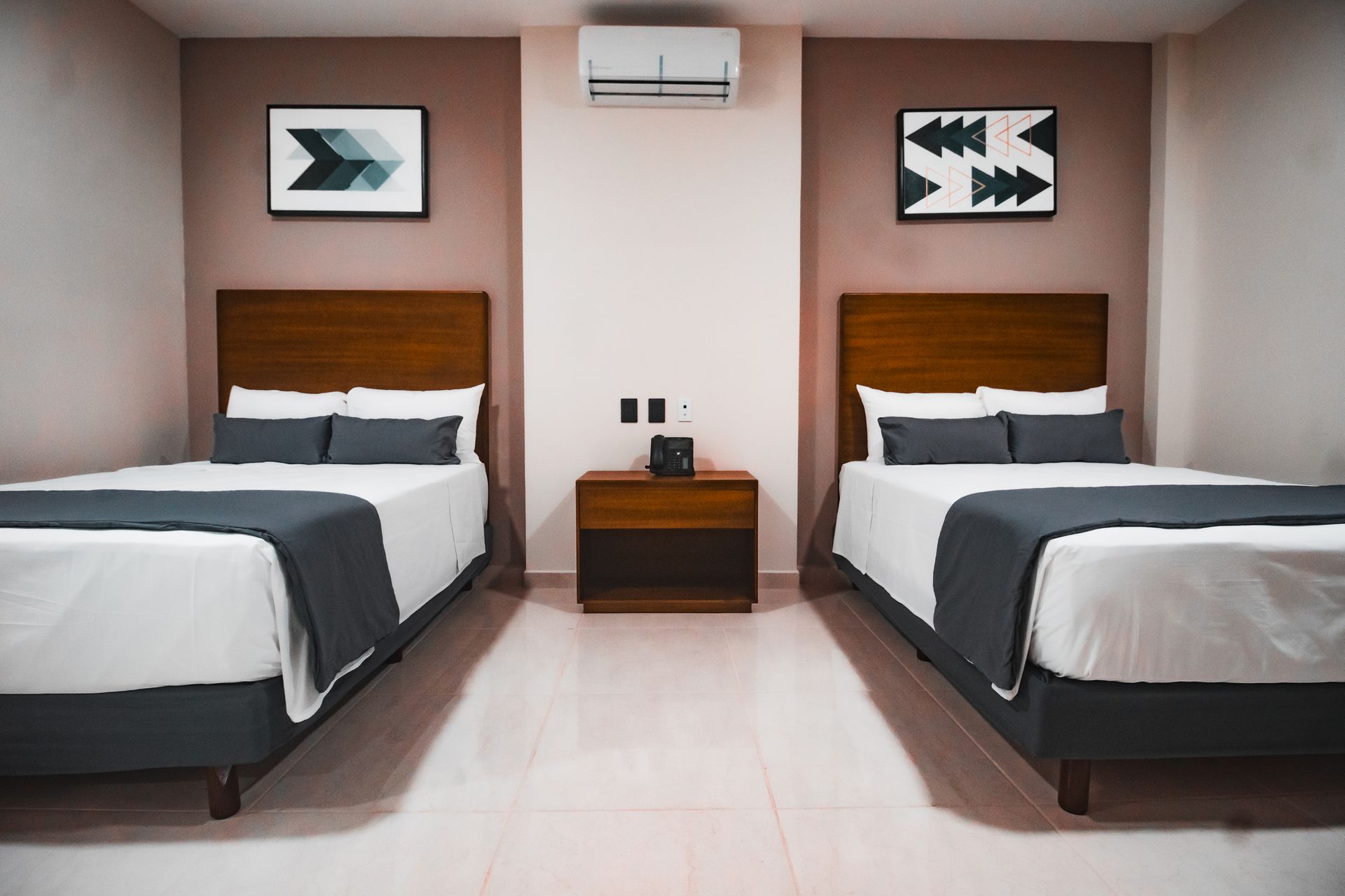 Una habitación de hotel con dos camas y una mesita de noche.