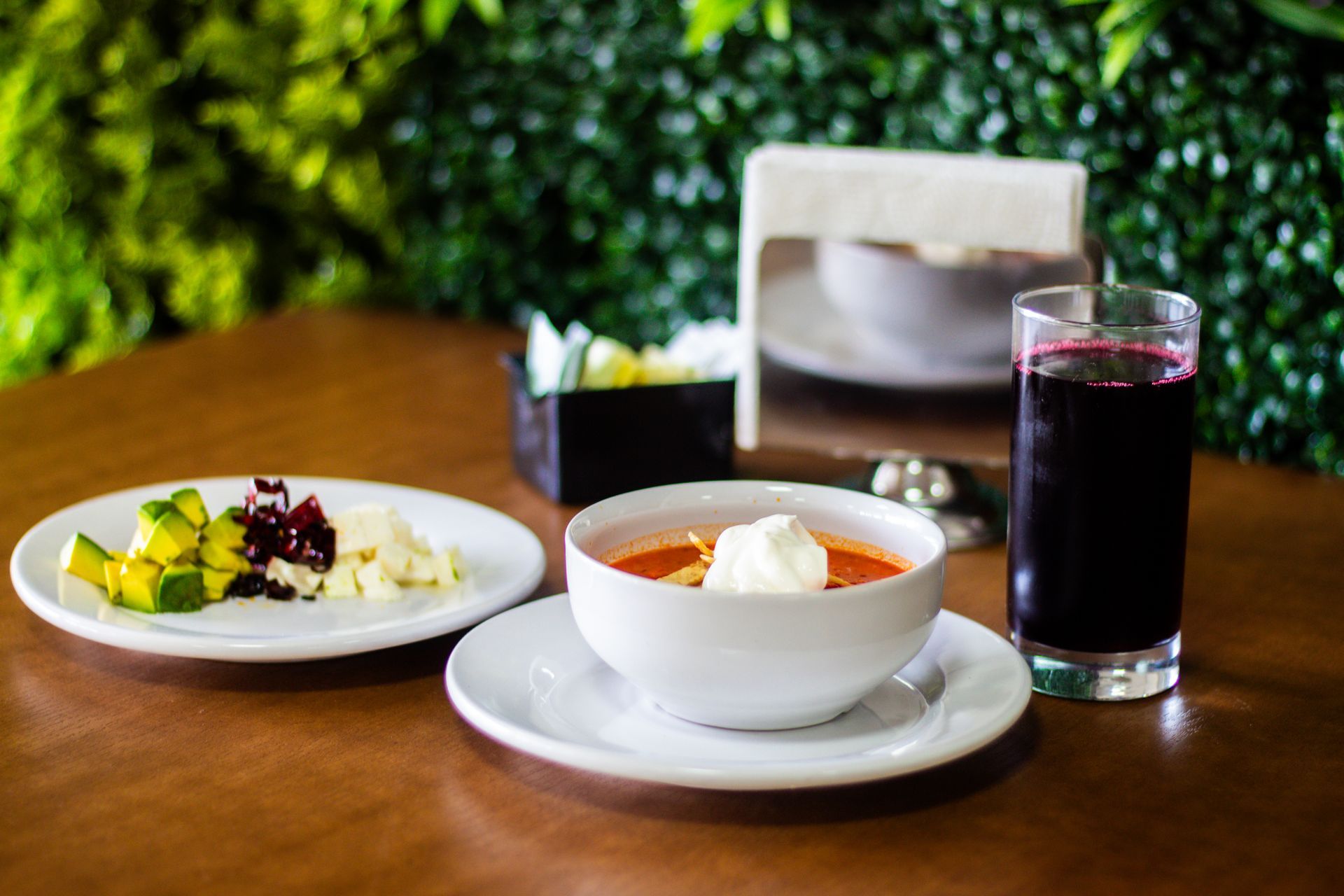 Hay un tazón de sopa y un vaso de jugo en la mesa.