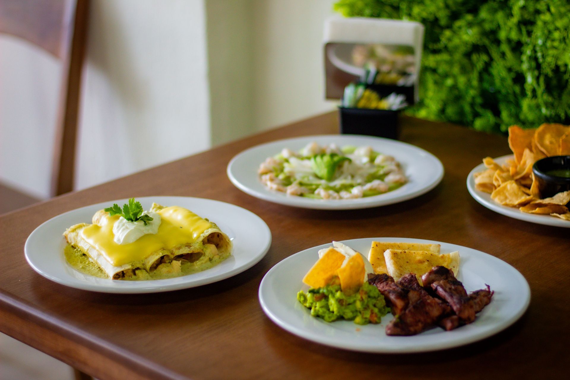 Tres platos de comida están sobre una mesa de madera.